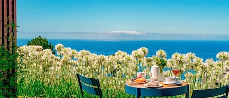 Uma mesa com uma refeição e vista para o mar.