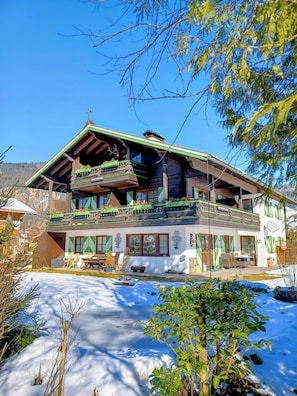 A chalet with a balcony, a dining area, and a view of the surrounding landscape.