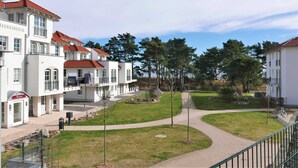 A hotel with multiple white buildings, red roofs, and a central pathway.