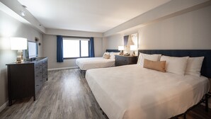 Une chambre d’hôtel avec deux lits, un bureau et une commode.