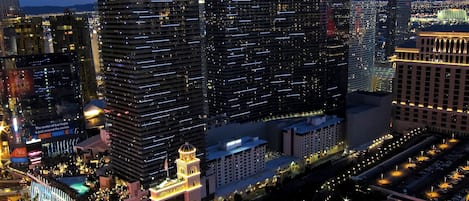 A high-rise hotel with multiple floors, a prominent sign, and a large illuminated structure nearby.