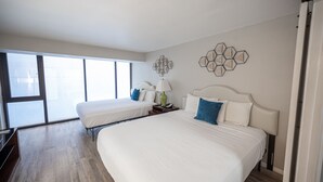 A hotel room with two beds, a large window, and a geometric wall decoration. - Stay Together Suites | Strip Condotel (Las Vegas)