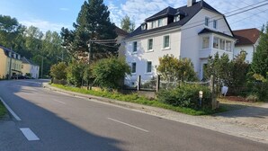 Een woonstraat met huizen, een verhard voetpad en een heldere lucht.