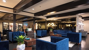 A lobby with blue sofas, a wooden coffee table, and a potted plant. - Stay Together Suites | Cozy Strip Condo (Las Vegas)