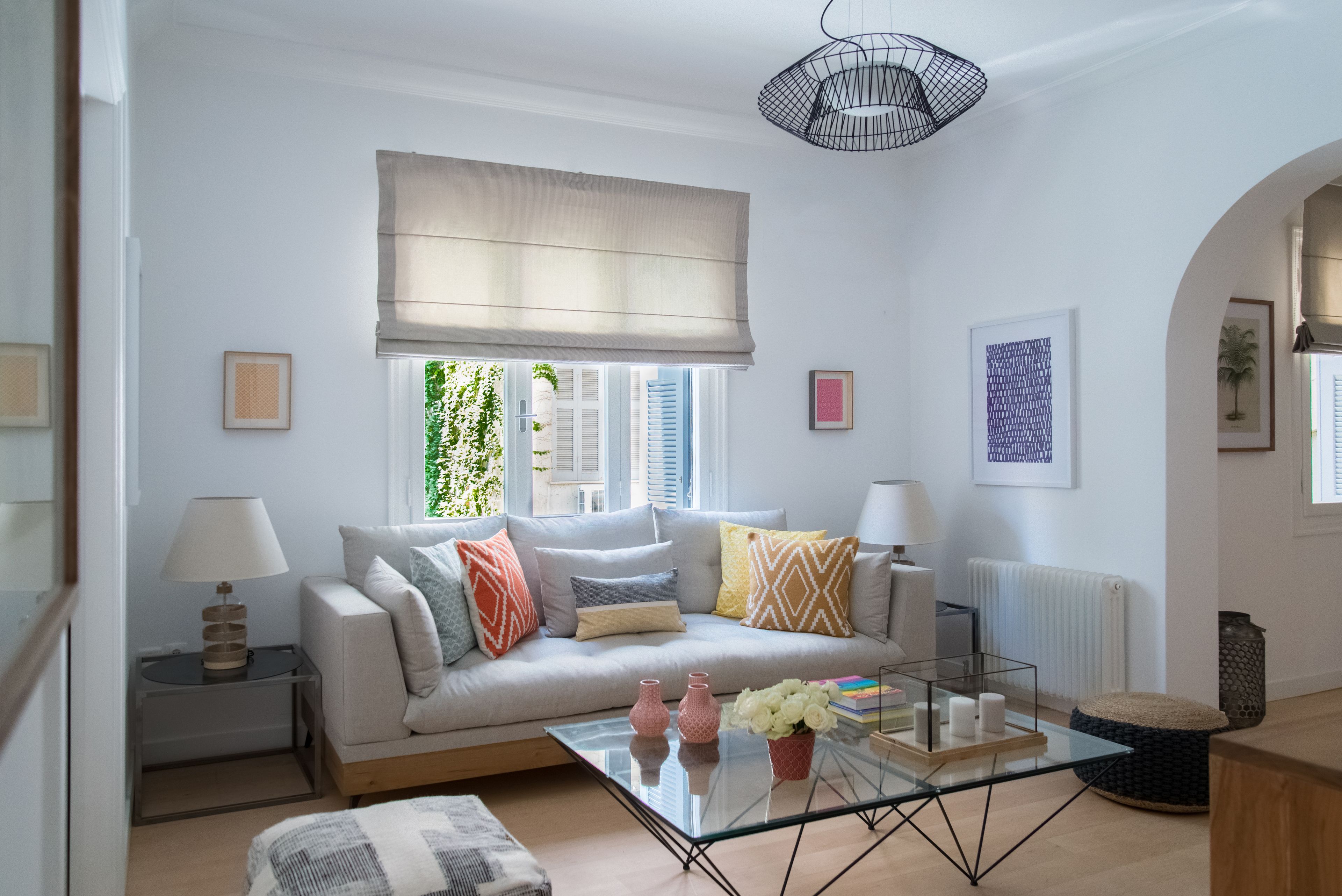 A modern living room with a sofa, coffee table, and lamps.