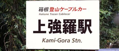 A sign with Japanese text and English translation for Hakone Tozan Cablecar and Kami-Gora Stn.