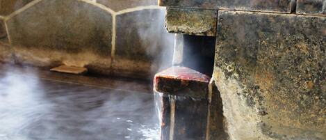 A stone wall with a steam vent.