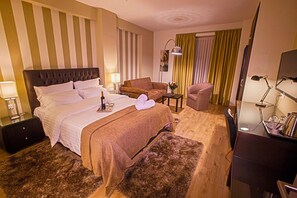 Habitación superior, 1 cama King size y sofá cama | Área de sala de estar | Televisión LCD 