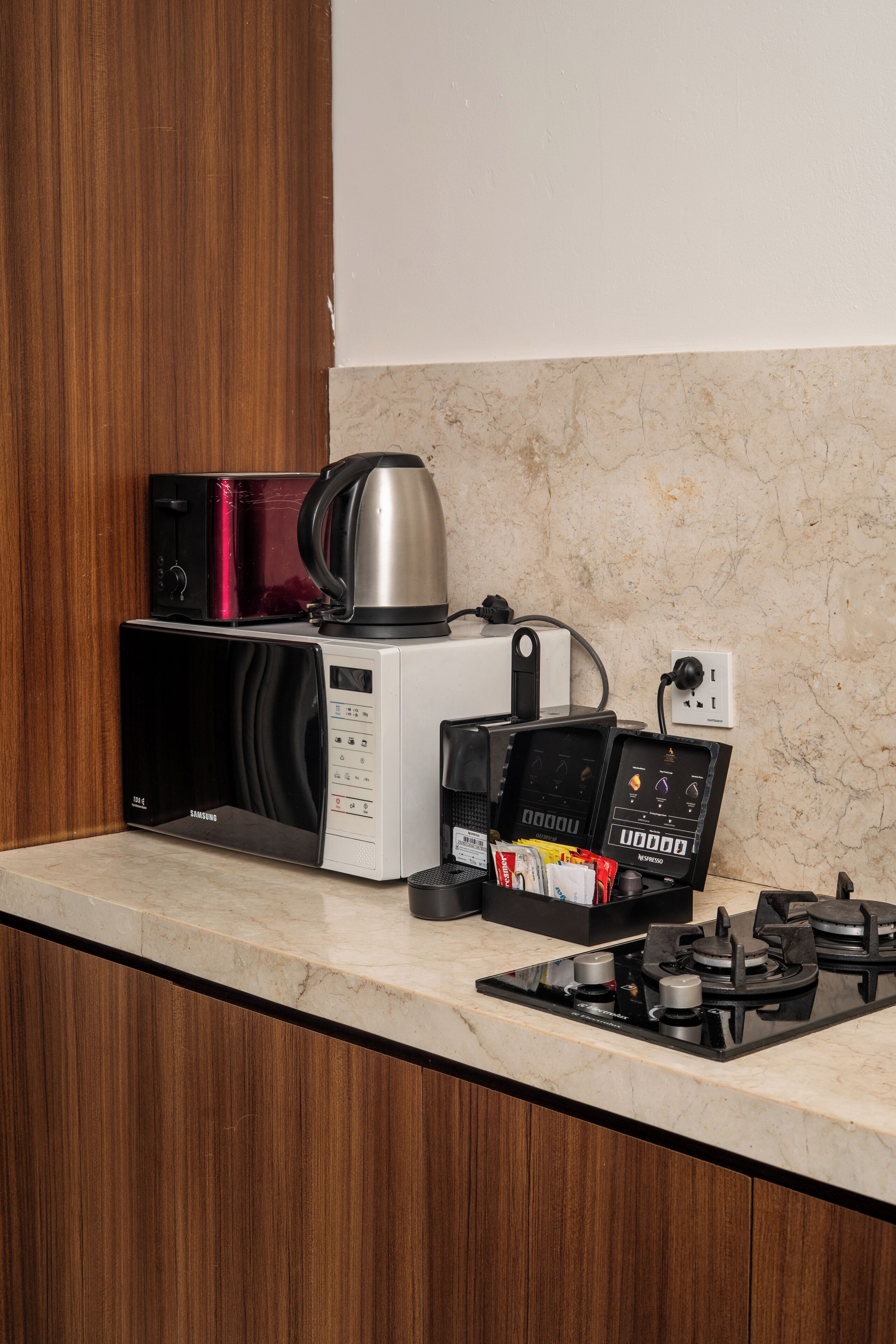 Une cuisine équipée d’un four à micro-ondes, d’une machine à café et d’une cuisinière à gaz.