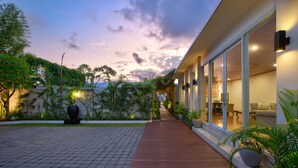 Um hotel moderno com deck de madeira, janelas amplas e vista para o oceano.