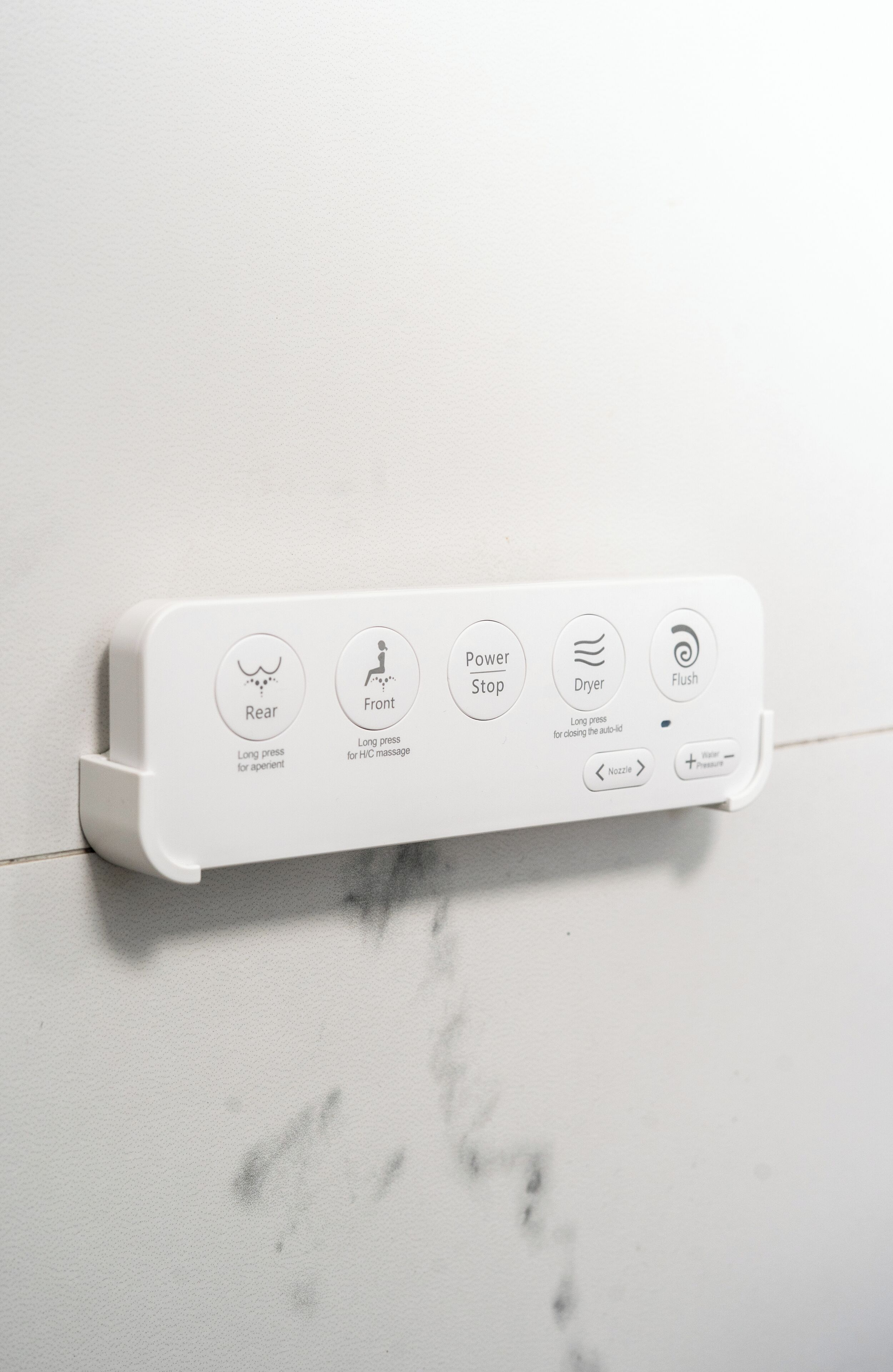 A control panel with icons for rear, front, power stop, dryer, and flush functions.