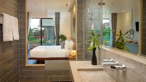 Un baño moderno con un espejo grande, ducha y lavabo.