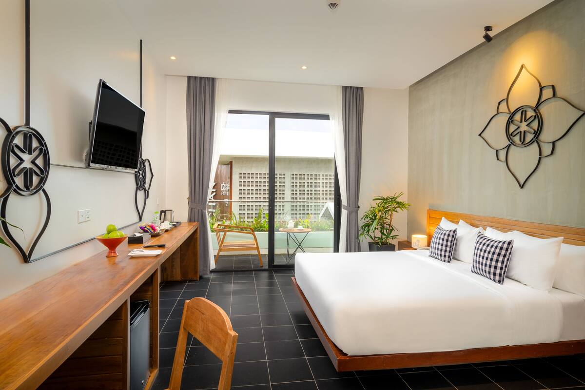 Una habitación de hotel con cama, escritorio y televisión.