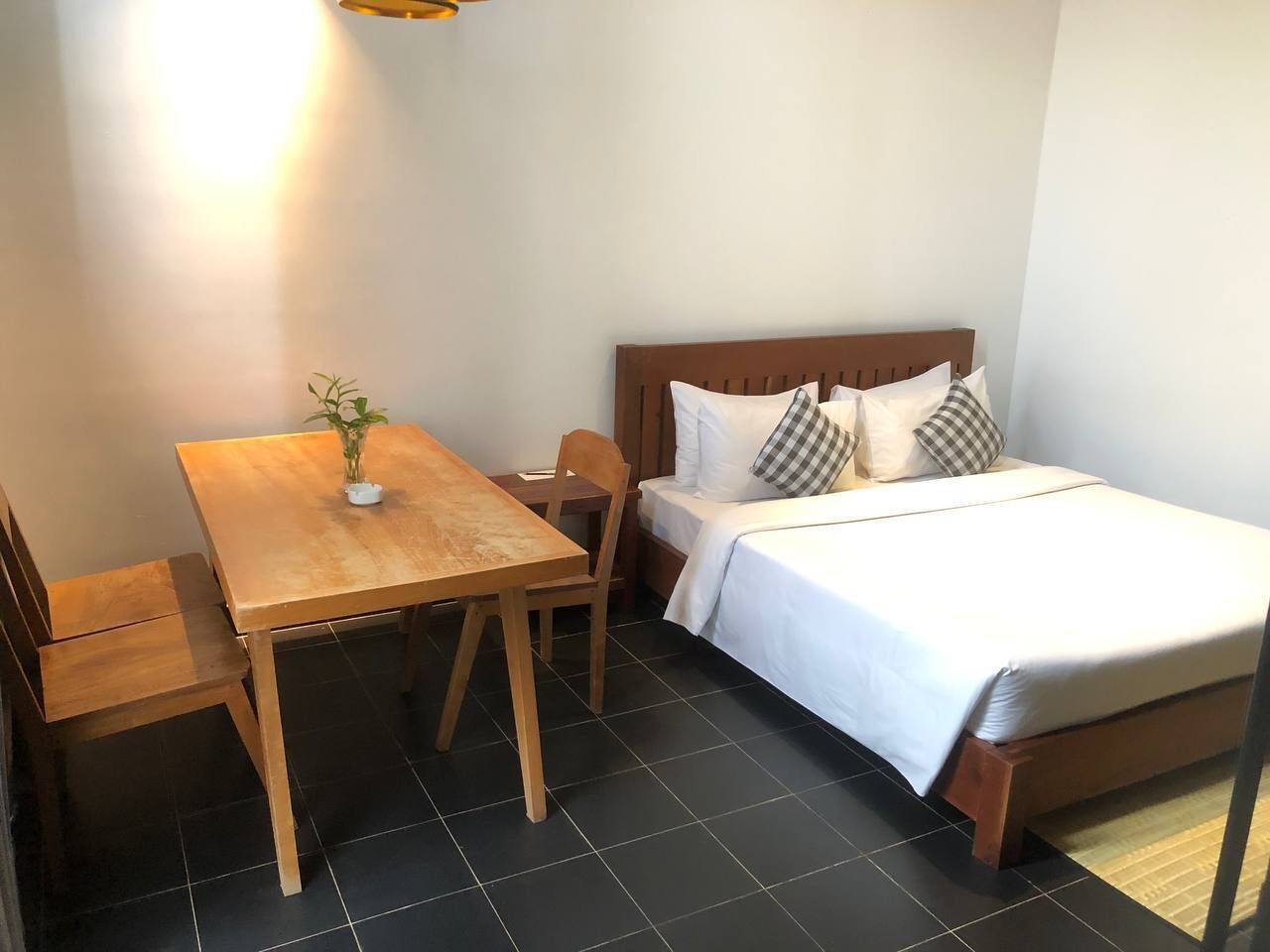 A small room with a bed, a wooden table, and a chair.