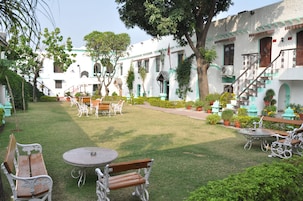 A courtyard with a dining area, benches, and potted plants.