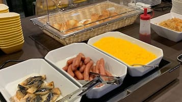 A buffet with various food items including sausages, cheese, and fish.