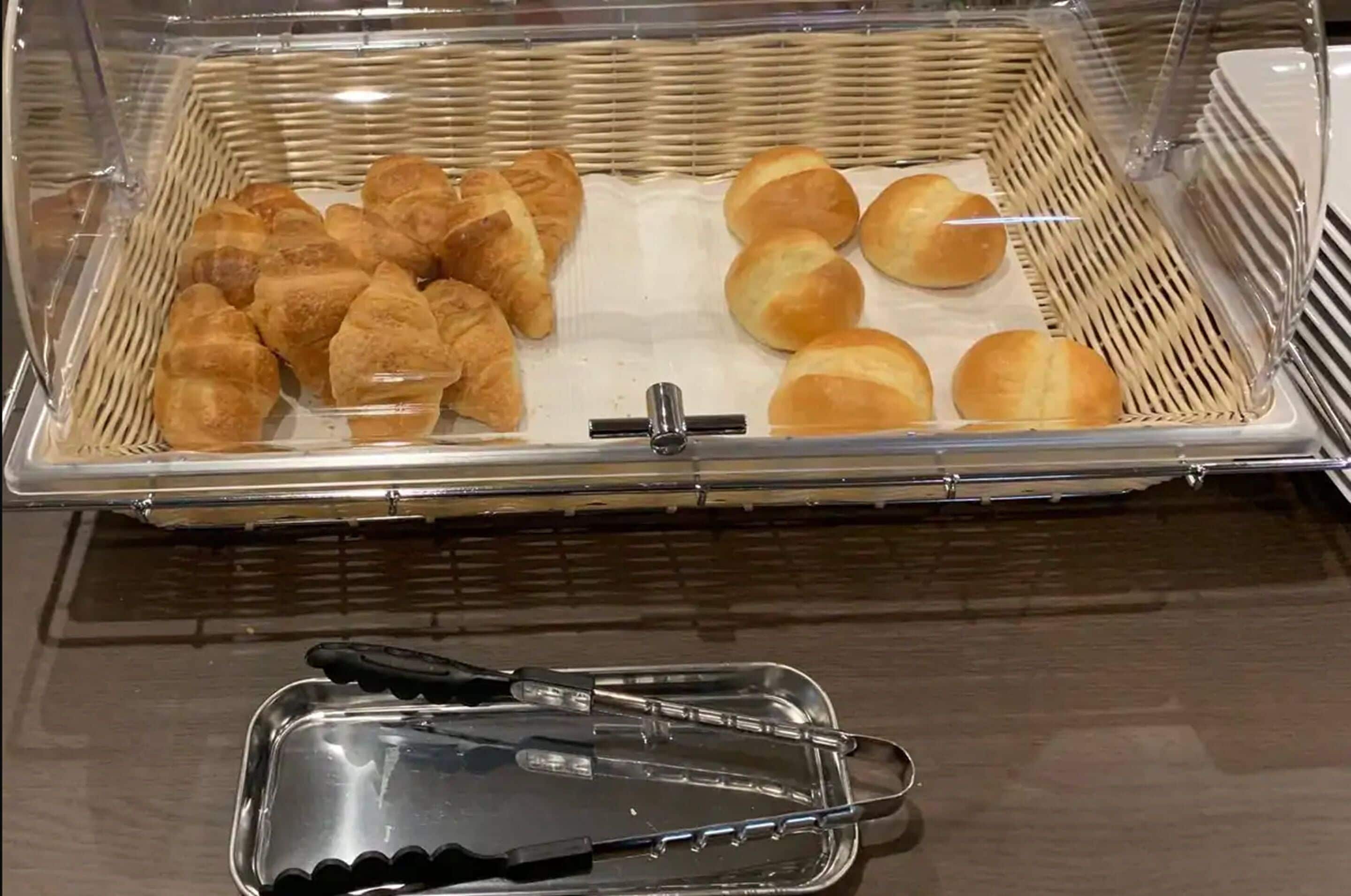 Vitrina de panadería con cruasanes y panes.
