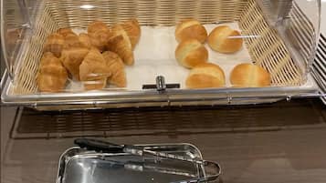 Vitrina de panadería con cruasanes y panes.