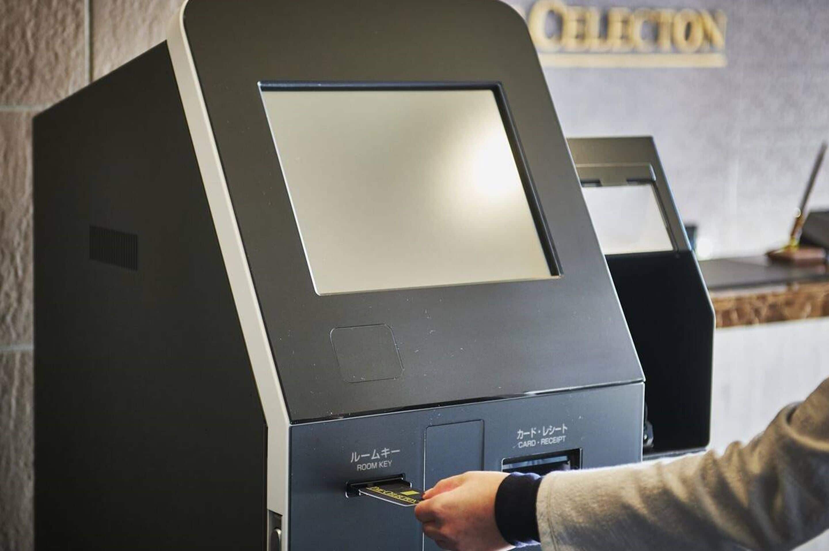 A hotel reception desk with a card reader and a room key machine.