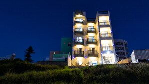 A multi-story building with balconies and windows, surrounded by greenery. - Jia Xiang Lin Guan Hai Homestay 2 (Magong)