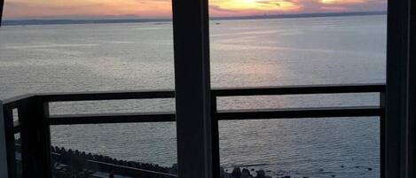 A room with a view of the sea at sunset.