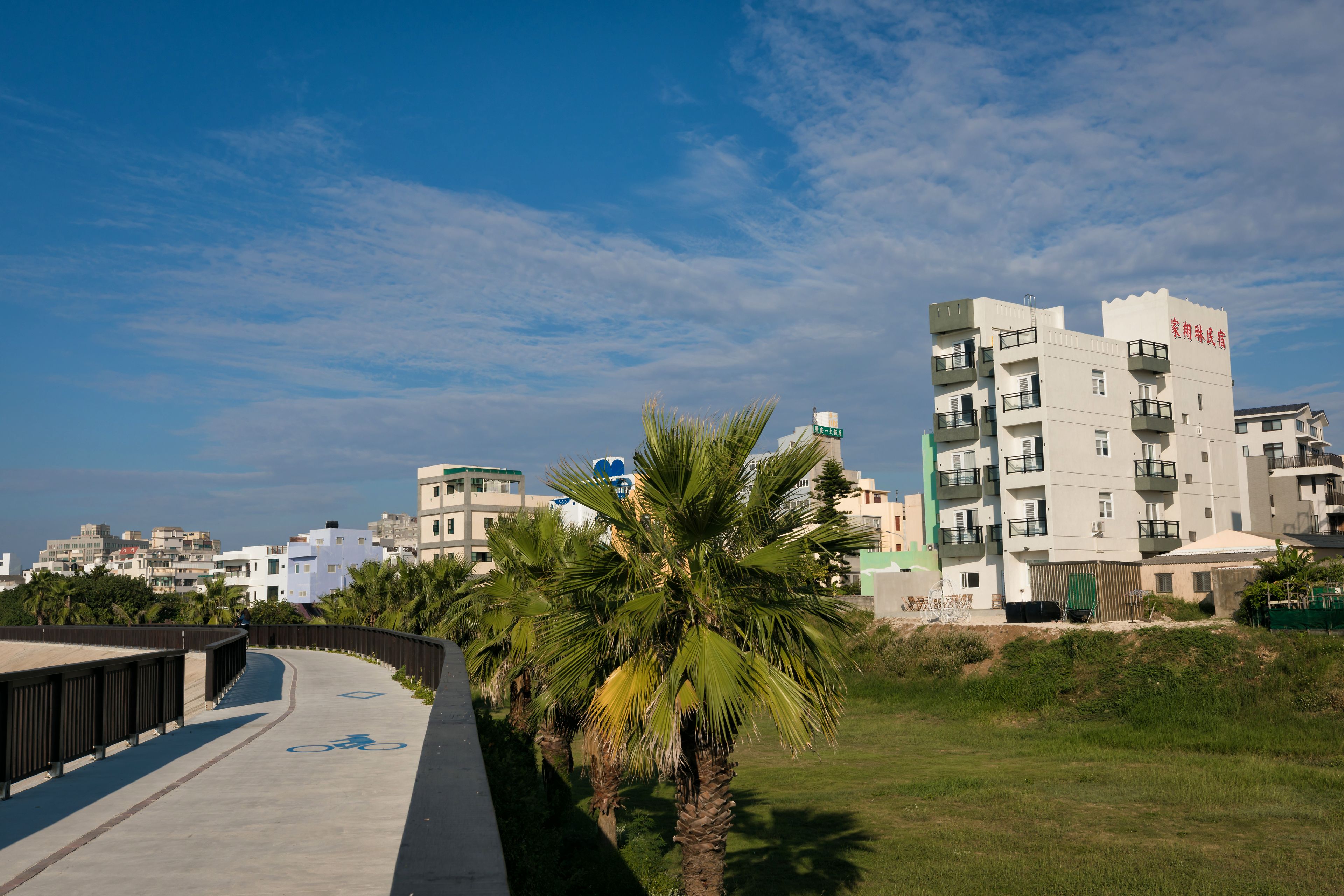 A modern building with balconies and a bike path nearby.