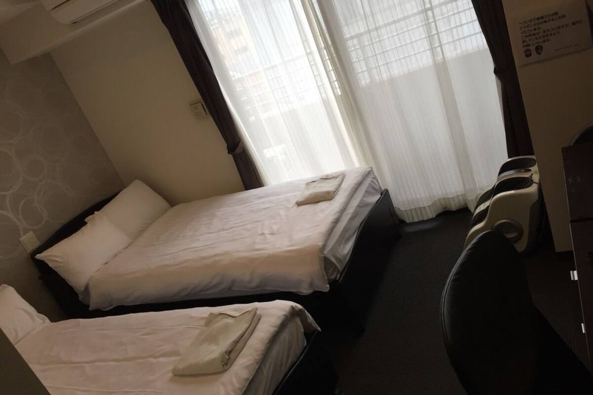 Una habitación de hotel con dos camas, un escritorio y una silla.