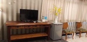 Relax in this cozy space with a flat-screen TV, refrigerator, and comfortable chairs.