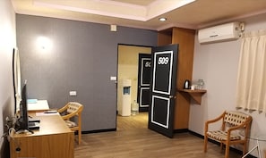 Stay in comfort with a desk, seating area, and air conditioning unit in this clean and well-appointed room.
