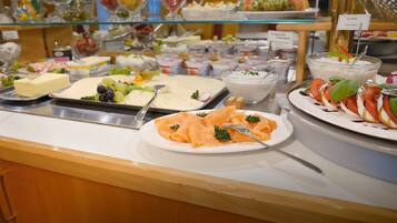 A buffet with various food items including salmon, salads, and dairy products.