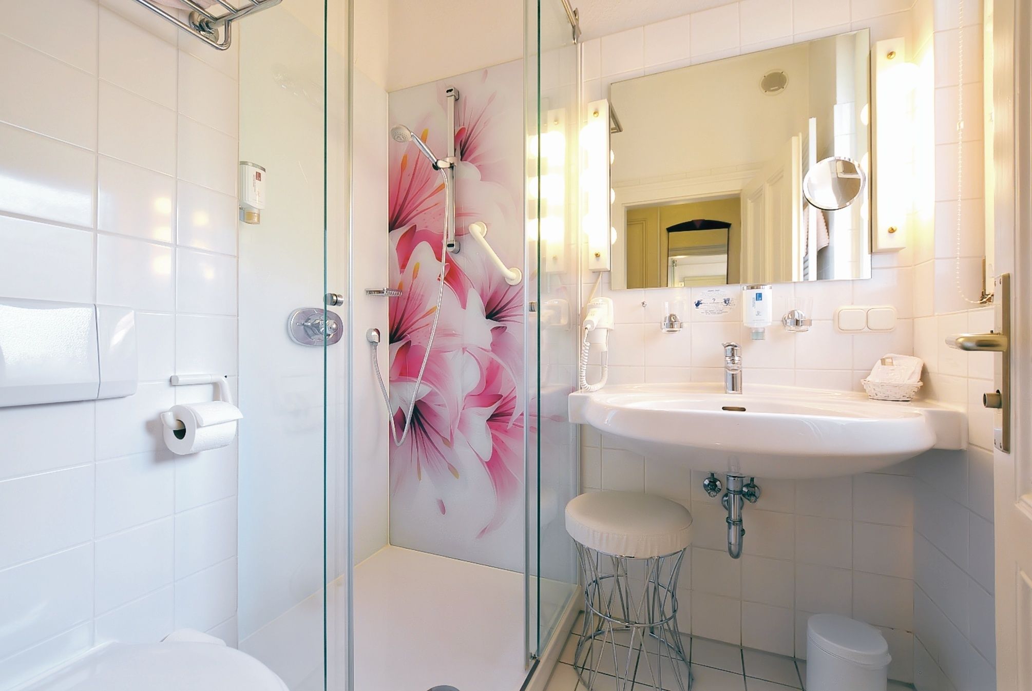 A modern bathroom with a glass-enclosed shower, a white sink, and a toilet.