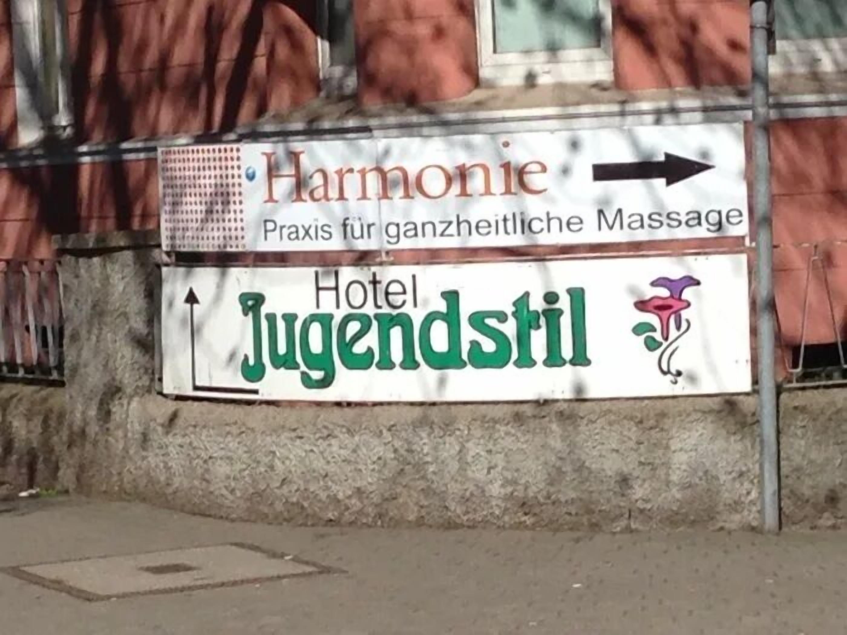 A sign for 'Hotel Jugendstil' with an arrow pointing to the right.