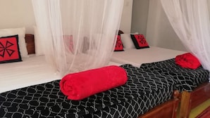 Une chambre à coucher avec deux lits, chacun doté d’un baldaquin.