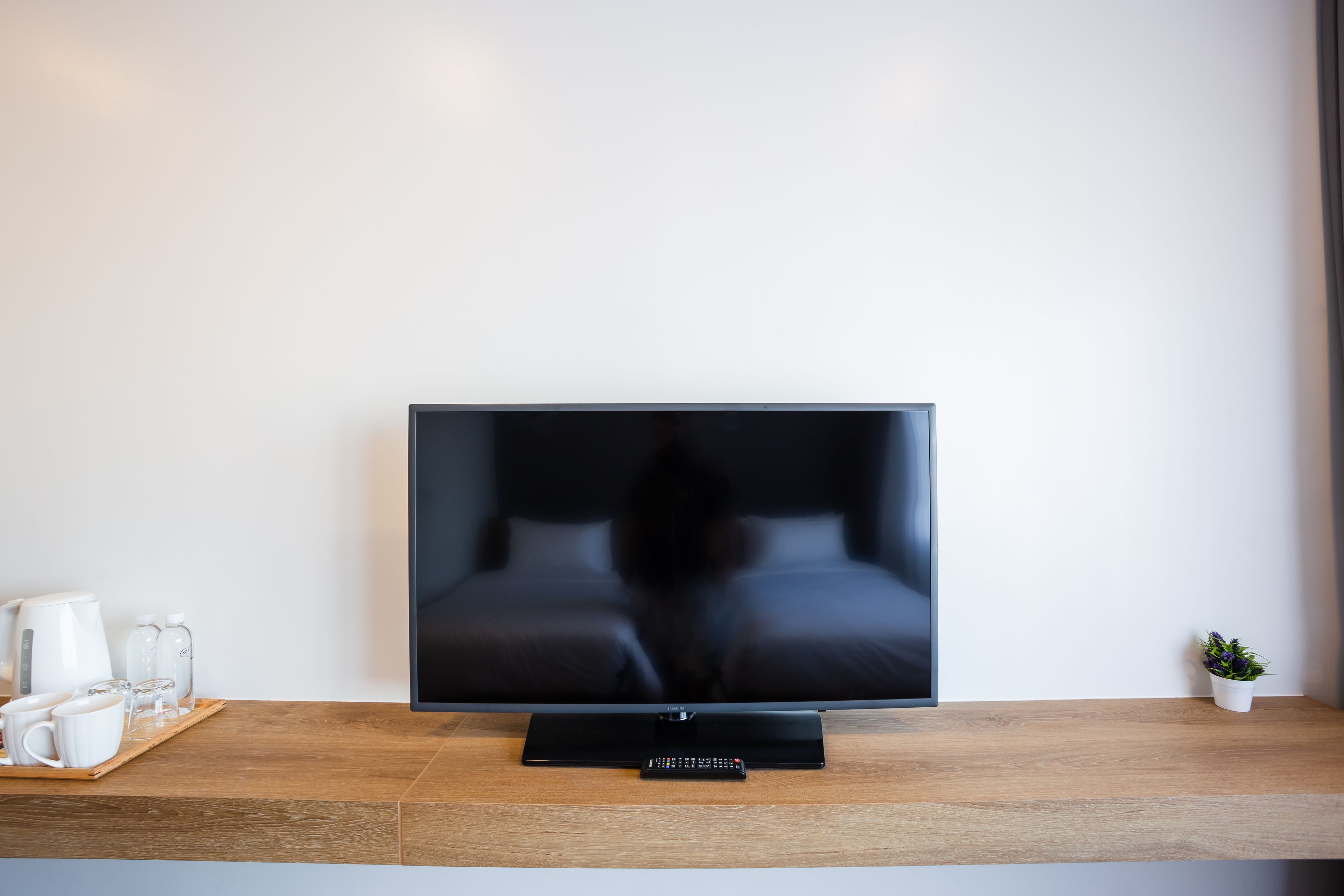 A flat-screen TV on a wooden stand in a hotel room.