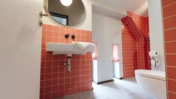 A bathroom with a white sink, a mirror, and a toilet.