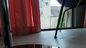 A view from a window with a metal frame and a curtain.