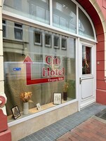 Ein Stadthotel mit gut leserlicher Beschilderung, einer Blumenkomposition und einem gerahmten Bild in der Schaufensterpräsentation.