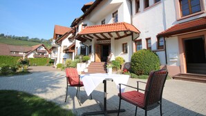 A restaurant with outdoor seating, a white tablecloth, and red chairs. - Hotel-Restaurant Hirsch Berghaupten (Berghaupten)