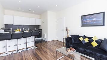 Apartamento executivo, 2 quartos, 2 banheiros, vista para o jardim | Sala de estar | TV de tela plana