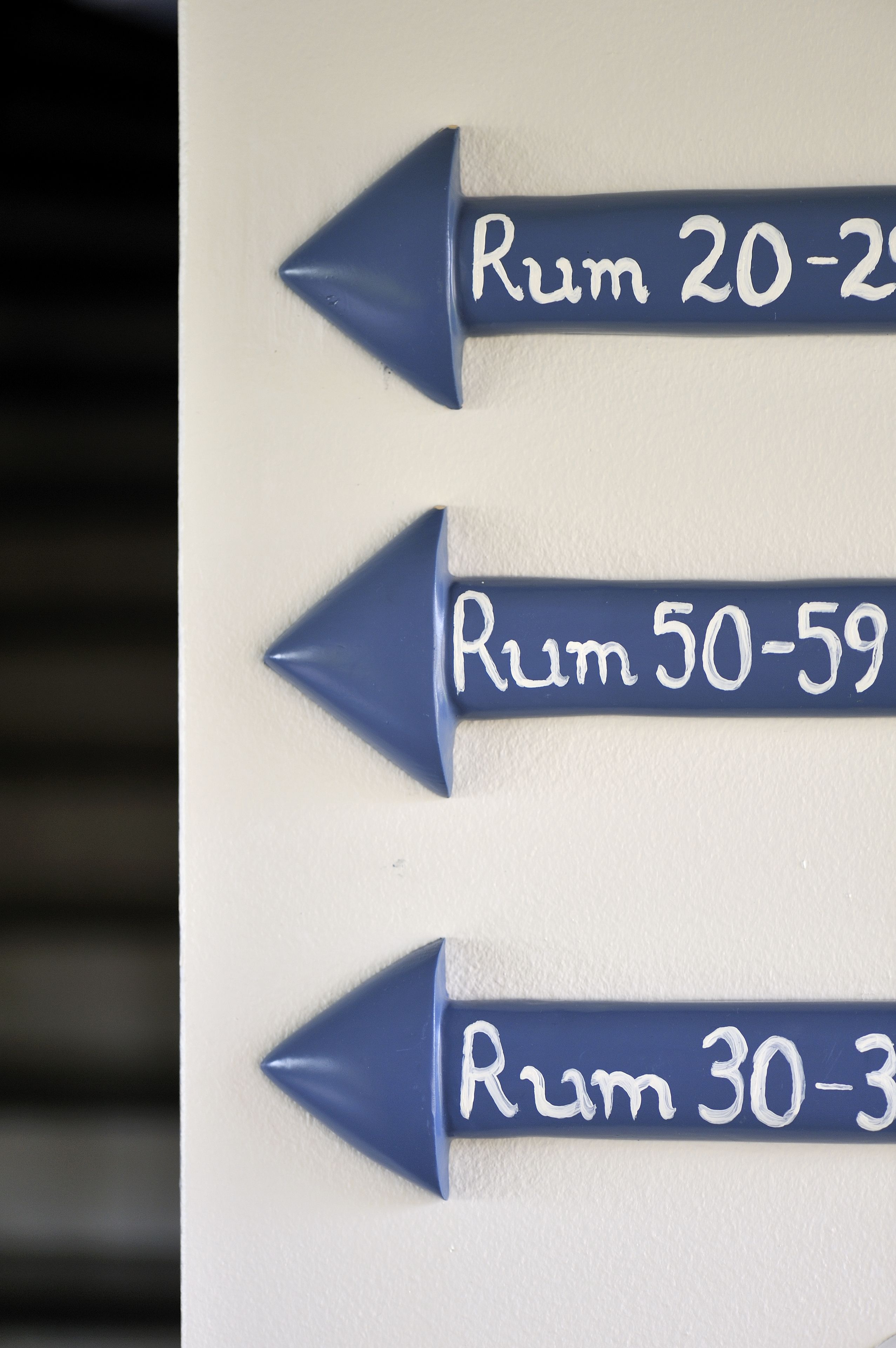 Directional signs with text indicating room numbers.