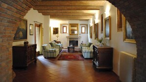 A spacious living room with a fireplace, comfortable seating, and framed artwork on the walls. - Verdidea - Il Tinaio (Monteroni d'Arbia)