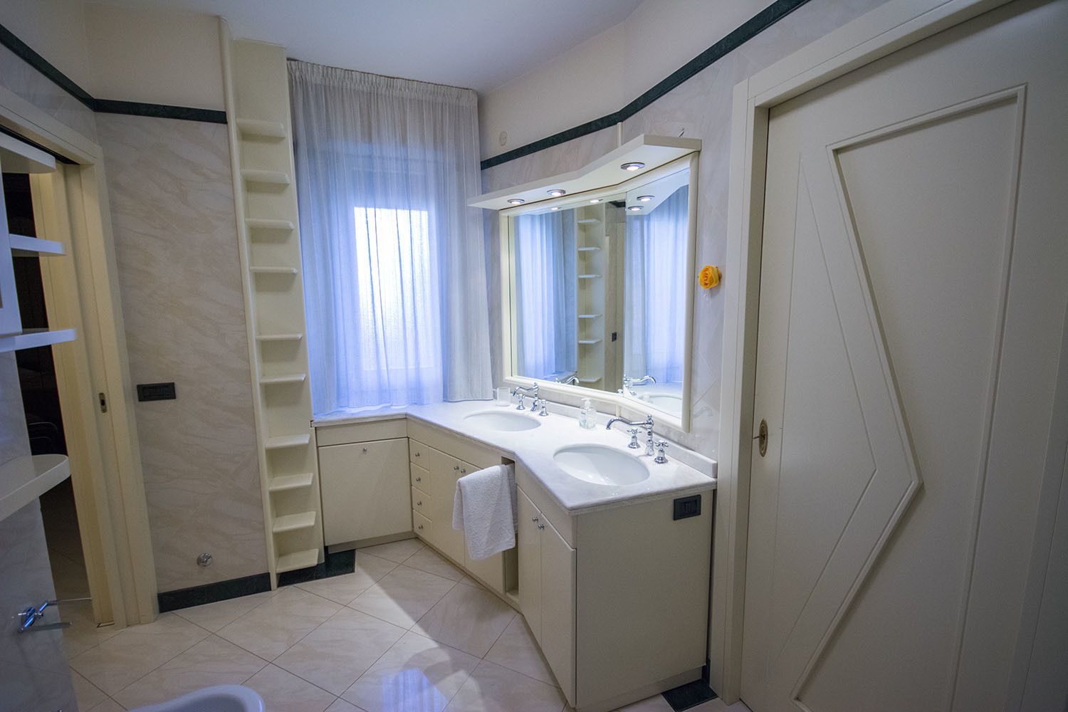 Casa de banho com duas pias, um espelho grande e um porta-toalhas.