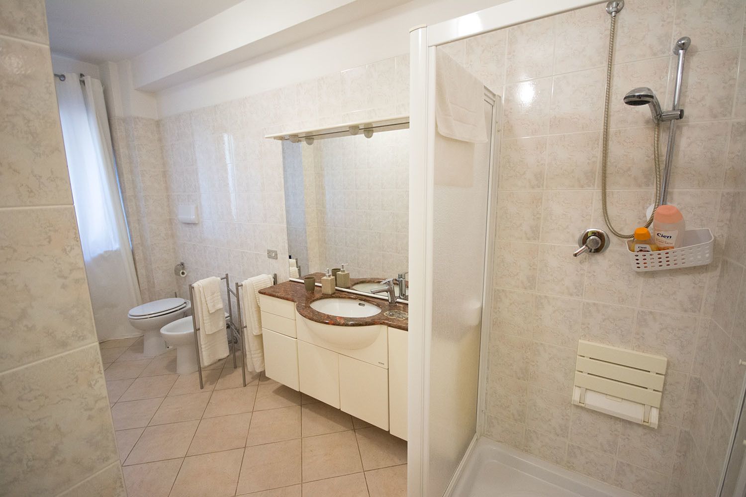 A bathroom with a toilet, sink, and shower.