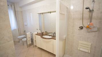 A bathroom with a toilet, sink, and shower.
