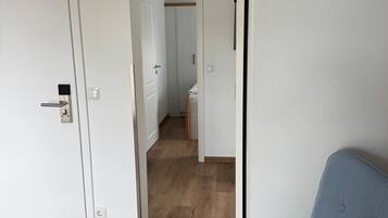 A room with a wooden floor, a blue chair, and white walls.