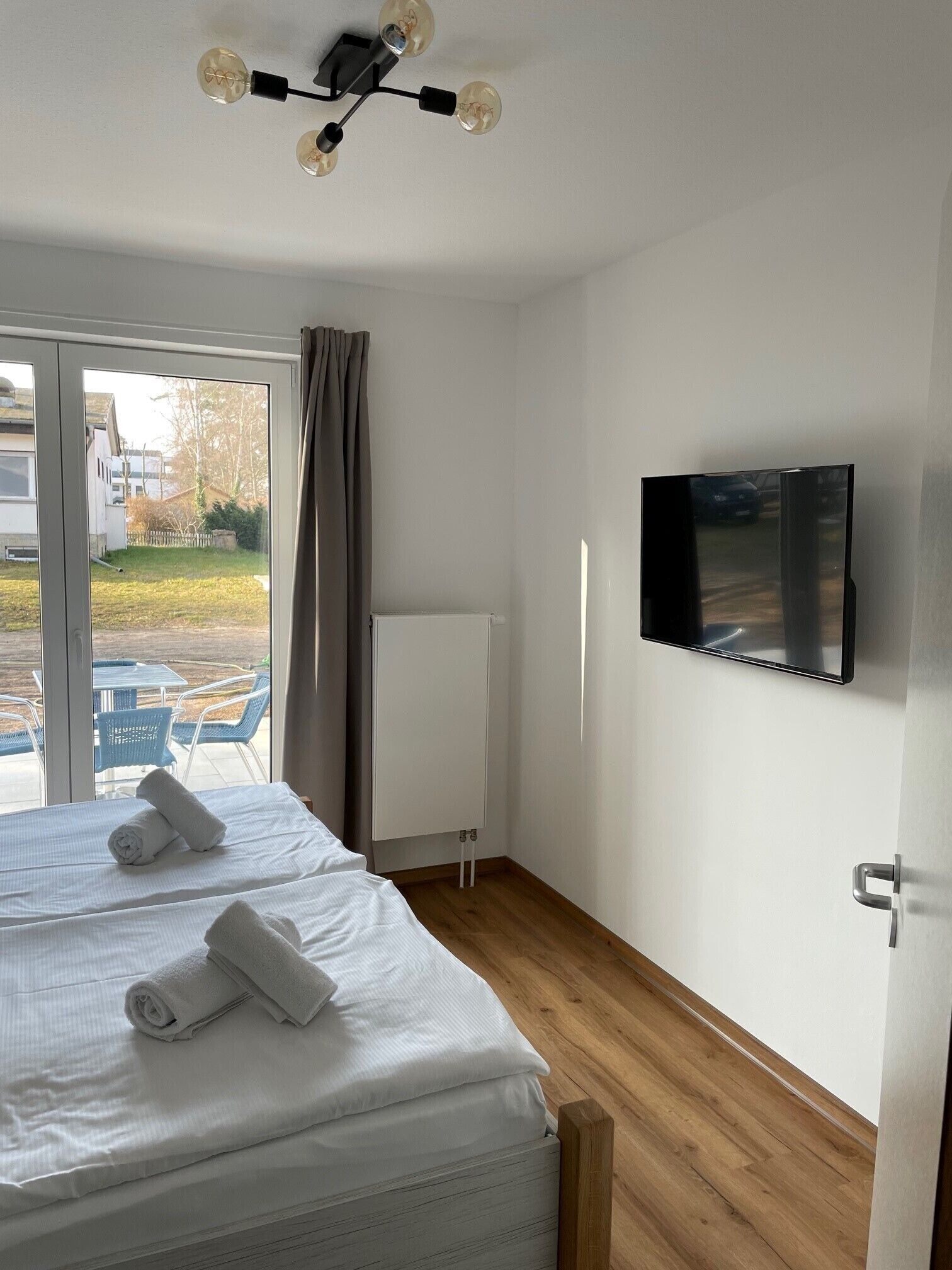 Una camera d'albergo con un letto, una TV, una lavagna e vista sull'esterno.