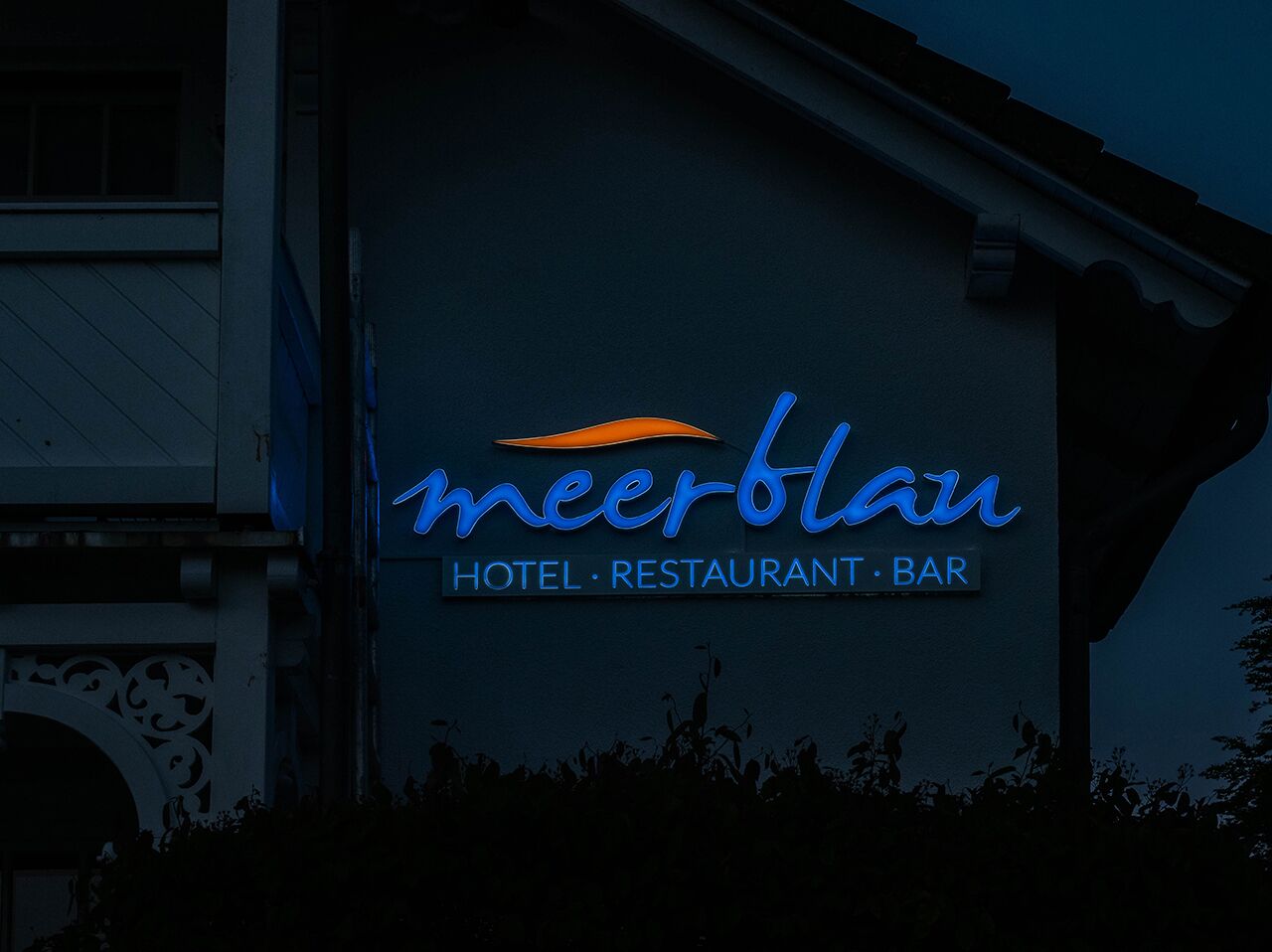 Um edifício com uma placa que diz "meerblau HOTEL RESTAURANT BAR".