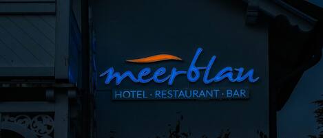 Rakennuksessa on kyltti, jossa lukee: ”meerblau HOTEL RESTAURANT BAR”.
