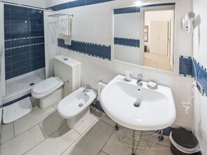 A bathroom with a toilet, bidet, sink, and a mirror. - B&B Solimena (Naples)