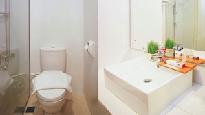 Moderni kylpyhuone, jossa on wc, suihku ja pesuallas sekä hygieniatarvikkeita.